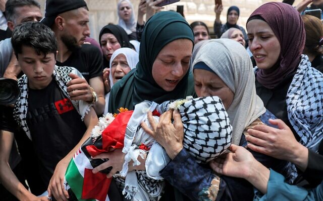 La mère (C) de Mohammed Haitham al-Tamimi, un garçon palestinien de 2,5 ans abattu accidentellement par Tsahal une semaine plus tôt, porte son corps lors des funérailles dans le village de Nabi Saleh, le 6 juin 2023. (Crédit : AHMAD GHARABLI / AFP)