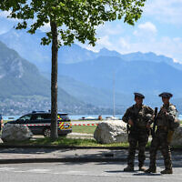 Un officier de police français (à gauche) et un Chasseur Alpin montent la garde près du lac d'Annecy, dans le centre-est de la France, le 8 juin 2023, à la suite d'une attaque au couteau dans la ville alpine française. (Crédit : OLIVIER CHASSIGNOLE / AFP)