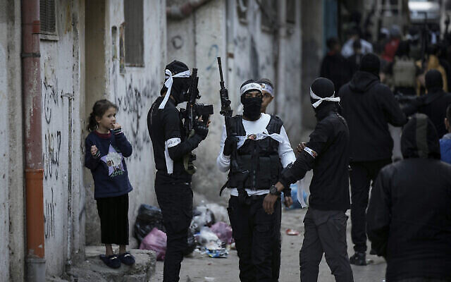 Illustration : Des Palestiniens masqués marchent dans Balata, le samedi 4 mars 2023. (Crédit : AP/Majdi Mohammed)