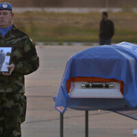 Un Casque bleu irlandais se tient à côté du cercueil de son camarade, le soldat Sean Rooney, tué près de la ville d'Al-Aqbiya, dans le sud du pays, lors d'un service commémoratif à l'aéroport de Beyrouth, le 18 décembre 2022. (Crédit : AP Photo/Hussein Malla, Archive)