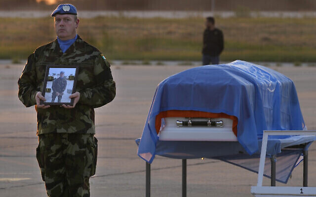 Un Casque bleu irlandais se tient à côté du cercueil de son camarade, le soldat Sean Rooney, tué près de la ville d'Al-Aqbiya, dans le sud du pays, lors d'un service commémoratif à l'aéroport de Beyrouth, le 18 décembre 2022. (Crédit : AP Photo/Hussein Malla, Archive)