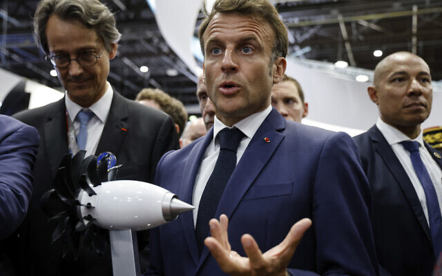 Le président français Emmanuel Macron fait un geste devant une maquette du moteur RISE de Safran au Salon international de l'aéronautique et de l'espace de Paris Le Bourget, lundi 19 juin 2023. (Crédit : Ludovic Marin, Pool via AP)