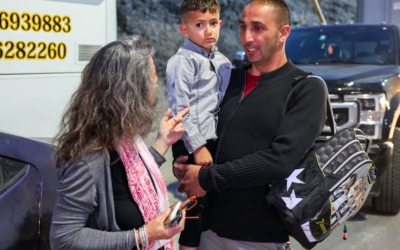Adam Abu al-Rob, un Palestinien de six ans qui a récemment eu un cancer des yeux, est porté par son père Mamoun alors qu'ils rencontrent la bénévole d'une ONG israélienne Yaël Noy au poste de contrôle de Rehan entre Israël et la Cisjordanie, qui les conduira à l'hôpital Sheba Tel Hashomer près de Tel Aviv, le 22 mai 2023. (Crédit : Jack Guez)