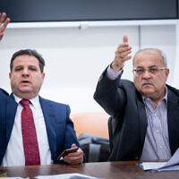 Le chef de Hadash-Taal, le député Ayman Odeh et le député Ahmad Tibi accueillant la réunion de leur faction à la Knesset, le 5 juin 2023. (Crédit : Yonatan Sindel/Flash90)