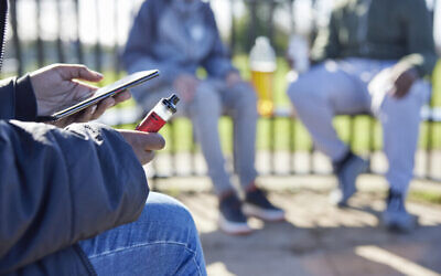 Des adolescents vapotent dans un parc (Crédit : iStock)