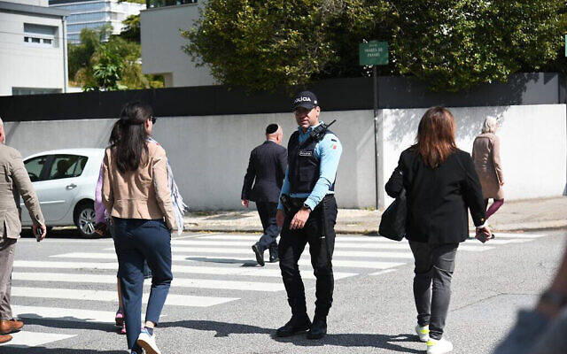 Un policier bloque une route pour les visiteurs de la synagogue Kadoorie à Porto, au Portugal, le le 16 mai 2023. (Crédit : Eli Mandelbaum/EJA)