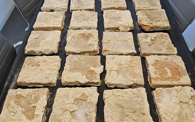 Des dizaines de briques antiques fabriquées par la 10e légion romaine découvertes par la police dans le coffre d'une voiture à Beit Hanina, à Jérusalem-Est, en mai 2023. (Crédit : Autorité israélienne des Antiquités)