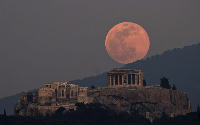 La lune se lève sur le Parthénon sur l'ancienne colline de l'Acropole à Athènes, en Grèce, le 19 février 2019. (Crédit : Petros Giannakouris/AP)
