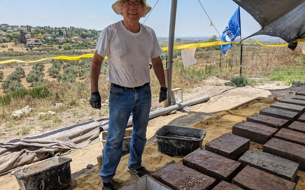 Albert Twizer, un programmeur informatique à la retraite, aujourd’hui un bénévole régulier sur les fouilles de l'IAA, est photographié ici en train de fabriquer des briques pour Tel Gezer, le 6 juillet 2023. (Crédit : Melanie Lidman/Times of Israel)