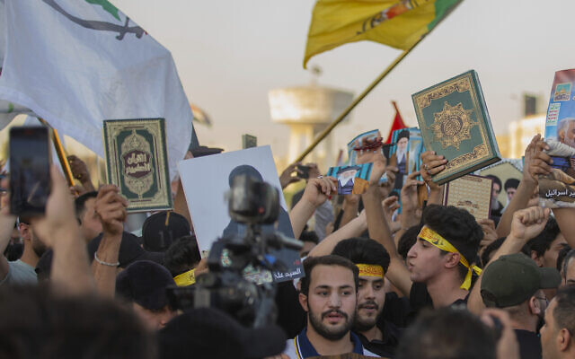 En réponse à l'incendie du Coran en Suède, des Irakiens brandissant des exemplaires du Coran, le livre saint des musulmans, lors d'une manifestation sur la place Tahrir, à Bagdad, en Irak, le 20 juillet 2023 (Crédit : Adil aL-Khazali/AP)