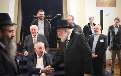 L'ancien grand rabbin ashkénaze d'Israël, Yisrael Meir Lau, serre la main du survivant de l'Holocauste Felix Goldschmied à la synagogue de Launceston, à Launceston, en Australie, le 12 juillet 2023. (Crédit : Mishka Gora)