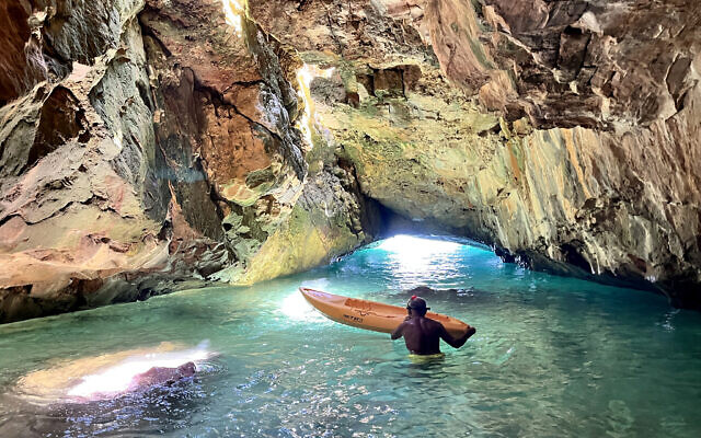 Le plongeur Victor Farah navigant en kayak à l'intérieur d'une grotte marine, considérée comme un sanctuaire pour les phoques, dans le village d'Amchit, au nord du Liban, le 12 juillet 2023. (Crédit : Etienne Torbey/AFP)