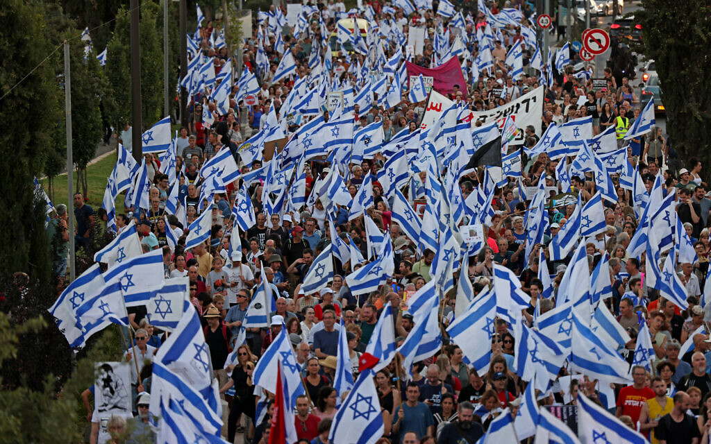 Des manifestants défilant avec des drapeaux nationaux lors d'une "journée de résistance" pour protester contre les projets de réforme judiciaire du gouvernement, près de la Cour suprême, à Jérusalem, le 18 juillet 2023. (Crédit : Ronaldo Schmidt/AFP)