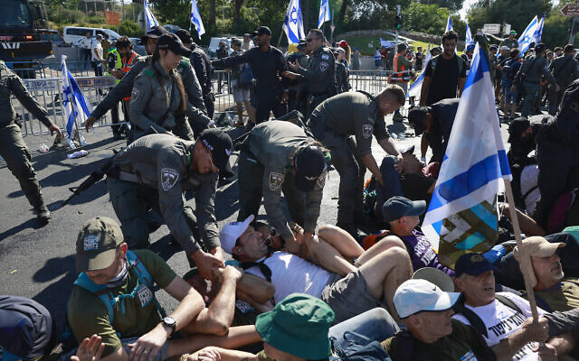 La police évacue des manifestants anti-refonte judiciaire qui bloquent une route près de la Knesset à Jérusalem, le 24 juillet 2023. (Crédit : Chaim Goldberg/Flash90)