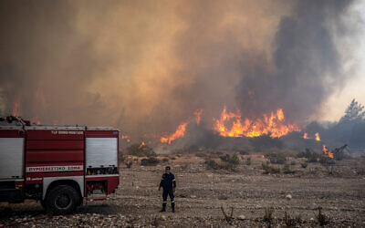 Un pompier lutte contre les incendies qui approchent le village de Vati, au nord de la ville côtière de Gennadi, dans la partie sud de l'île grecque de Rhodes, le 25 juillet 2023. (Crédit : Angelos Tzortzinis / AFP)