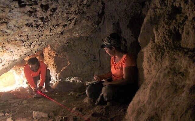 Ouria Amichai et Hagay Hamer, du Judean Desert Survey de l'IAA, explorent une grotte près d'Ein Gedi. (Crédit : Emil Aladjem/IAA)