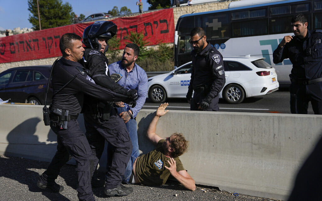 Des policiers israéliens dispersent des manifestants qui bloquent une autoroute menant à Jérusalem, lors d'une manifestation contre les projets du nouveau gouvernement du Premier ministre Benjamin Netanyahu visant à réformer le système judiciaire, le 11 juillet 2023. (Crédit : AP Photo/Ohad Zwigenberg)