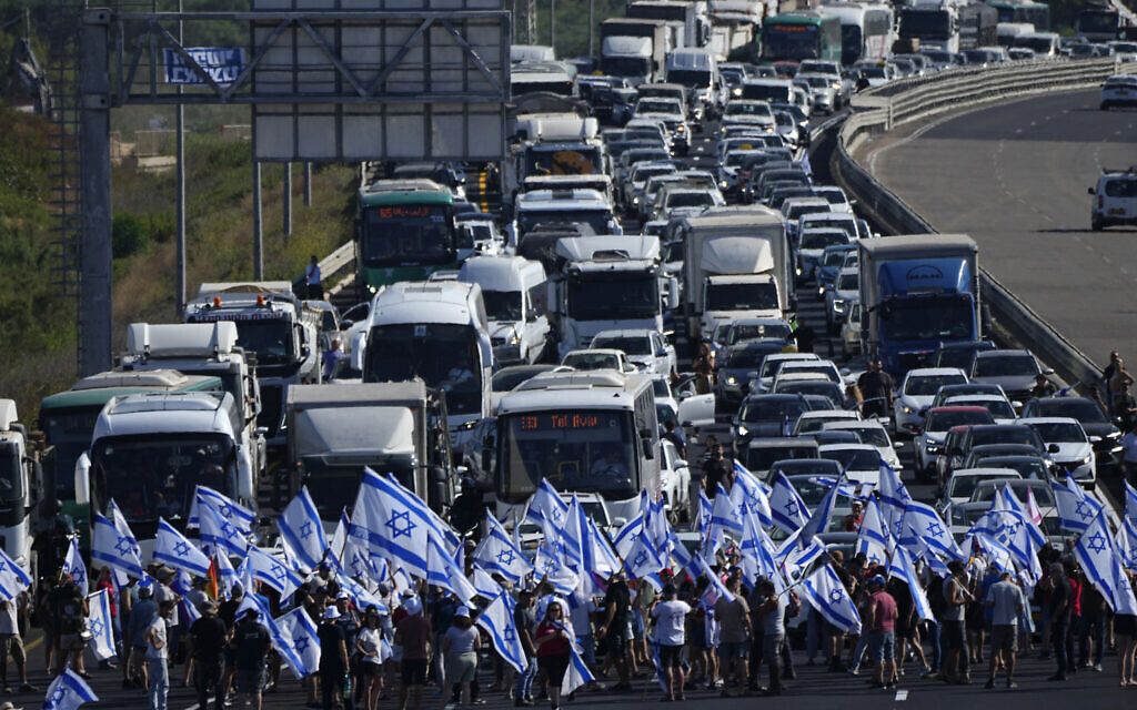Des manifestants israéliens bloquent l'autoroute Tel Aviv-Haïfa près de Beit Yanai, en Israël, lors d'une manifestation contre les projets du nouveau gouvernement du Premier ministre Benjamin Netanyahu visant à réformer le système judiciaire, mardi 11 juillet 2023. (Crédit : AP Photo/Ariel Schalit)