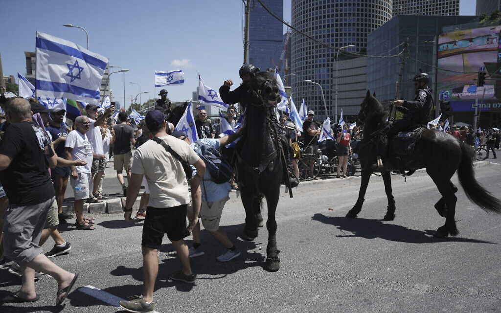 Des policiers israéliens à cheval dispersant des manifestants, à Tel Aviv, le 11 juillet 2023. (Crédit : AP Photo/Oded Balilty)