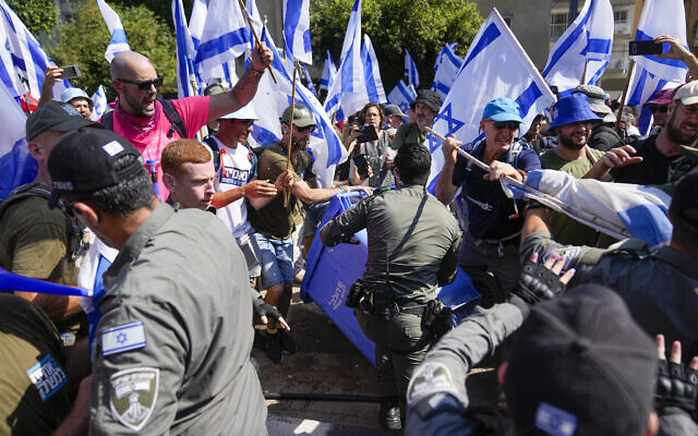Des Israéliens protestant contre les plans du gouvernement du Premier ministre Benjamin Netanyahu visant à réformer le système judiciaire se battant avec la police à Tel Aviv, en Israël, le 18 juillet 2023. (Crédit : AP Photo/Ohad Zwigenberg)