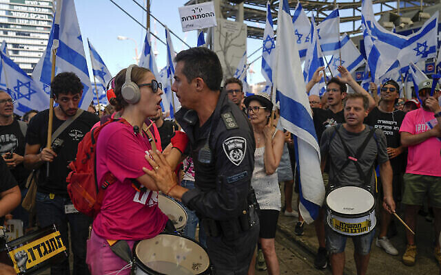 Un manifestant affronte avec un policier lors d'une manifestation contre les projets du gouvernement du Premier ministre Benjamin Netanyahu de réformer le système judiciaire à Tel Aviv, Israël, le 18 juillet 2023. (Crédit : AP Photo/Ariel Schalit)