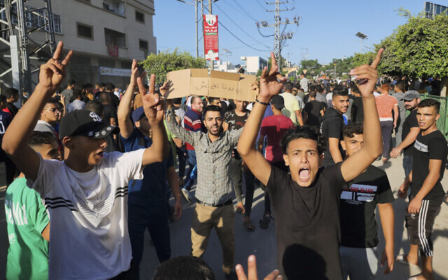 Des manifestants palestiniens scandant des slogans contre le Hamas lors d'une manifestation contre les pannes d'électricité chroniques et les conditions de vie difficiles dans les rues de Khan Younis, dans la Bande de Gaza, le 30 juillet 2023. (Crédit : AP Photo)