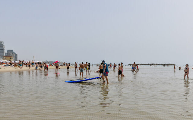 Des Israéliens profitant de la plage par une chaude journée d'été, à Tel Aviv, le 2 juin 2023. (Crédit : Avshalom Sassoni/Flash90)
