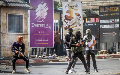 Des hommes armés palestiniens prenant position lors d'un affrontement avec l'armée israélienne dans la ville de Jénine, en Cisjordanie, le 3 juillet 2023. (Crédit : Nasser Ishtayeh/Flash90)