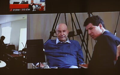 L'homme d'affaires Arnon Milchan sur un écran avant son témoignage dans l'Affaire 1000 dans le cadre du procès pour corruption du Premier ministre Benjamin Netanyahu, le 3 juillet 2023. (Crédit : Alex Kolomoisky/POOL/Flash90)