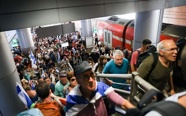 Des Israéliens, dont certains sont des manifestants anti-réforme, descendant du train à l'aéroport Ben Gurion, le 11 juillet 2023. (Crédit : Avshalom Sassoni/Flash90)