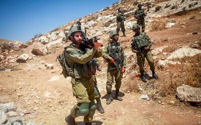 Des soldats israéliens montant la garde pendant que des Palestiniens et des militants de gauche manifestent dans le village de Beit Dajan, en Cisjordanie, le 21 juillet 2023. (Crédit : Nasser Ishtayeh/Flash90)