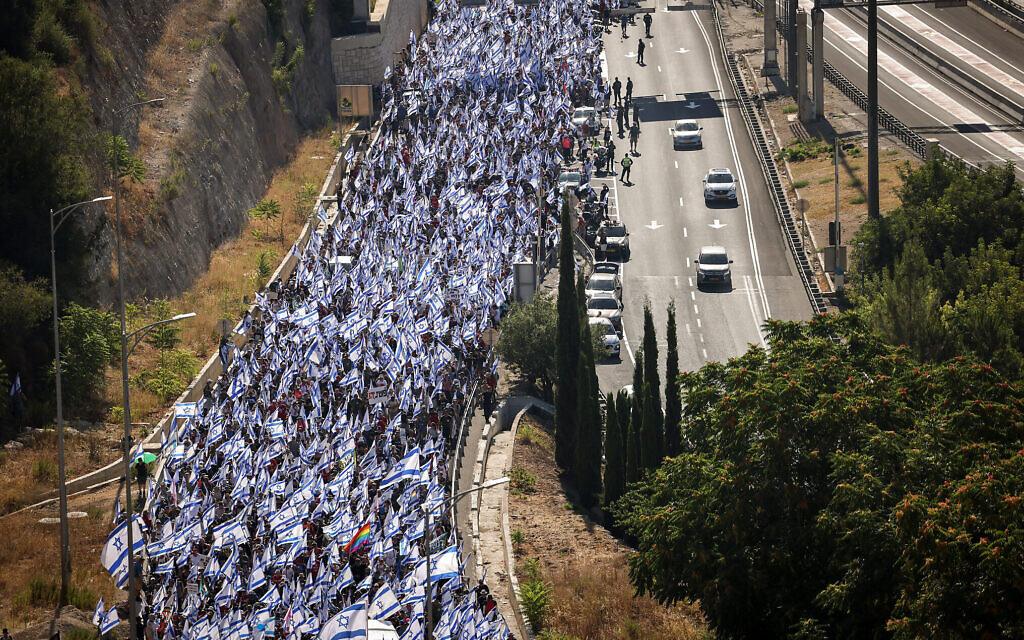  Des militants contre la réforme judiciaire marchant sur la Route 1 près de l'entrée de Jérusalem, le 22 juillet 2023. (Crédit : Yonatan Sindel/Flash90)