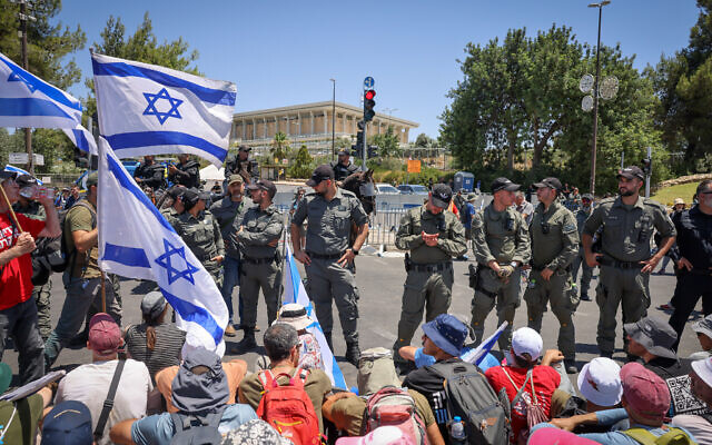 La police évacue des manifestants anti-refonte judiciaire qui bloquent une route près de la Knesset à Jérusalem, le 24 juillet 2023. (Crédit : Chaim Goldber/Flash90)