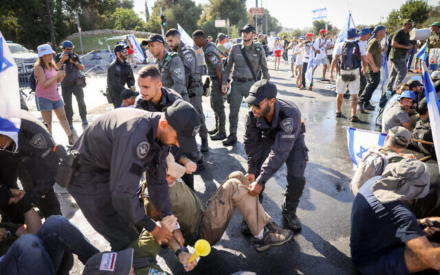 La police évacue des manifestants anti-refonte judiciaire qui bloquent une route près de la Knesset à Jérusalem, le 24 juillet 2023. (Crédit : Chaim Goldberg/Flash90)
