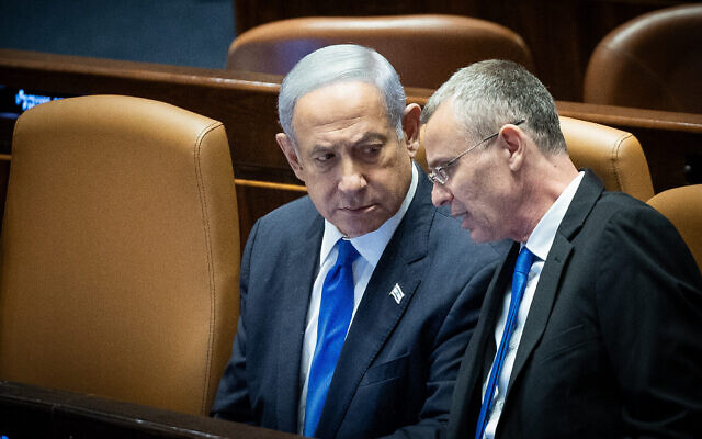 Le Premier ministre Benjamin Netanyahu et le ministre de la Justice Yariv Levin, dans le plénum de la Knesset lors d'un vote sur le projet de loi du "caractère raisonnable" de la coalition, le 24 juillet 2023. (Crédit : Yonatan Sindel/Flash90)