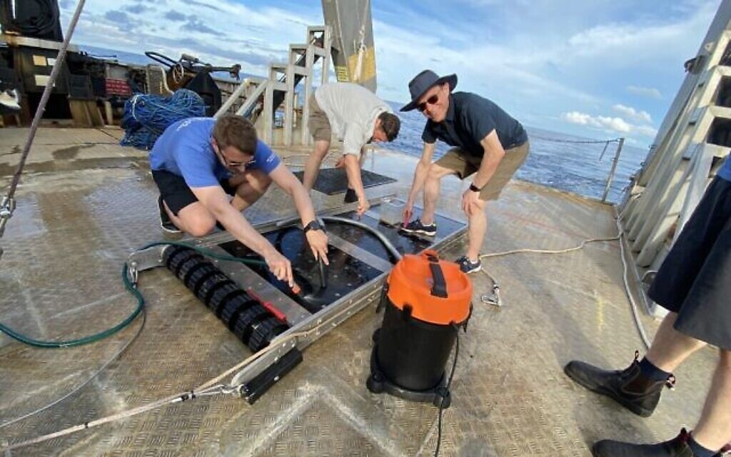 Le professeur Avi Loeb, au centre à droite, sourit alors qu'il travaille avec ses collègues scientifiques, au large des côtes de Papouasie-Nouvelle-Guinée, en juin 2023, pour identifier les parties d'un météore interstellaire  écrasé en 2014. (Avec l'aimable autorisation de Loeb)