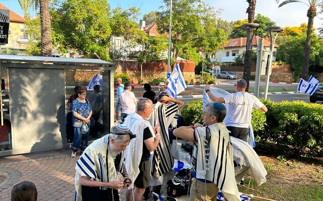 Des manifestants contre le remaniement judiciaire priant devant la maison du député du Likud Danny Danon, à Raanana, le 18 juillet 2023. (Crédit : Alon Korngreen)
