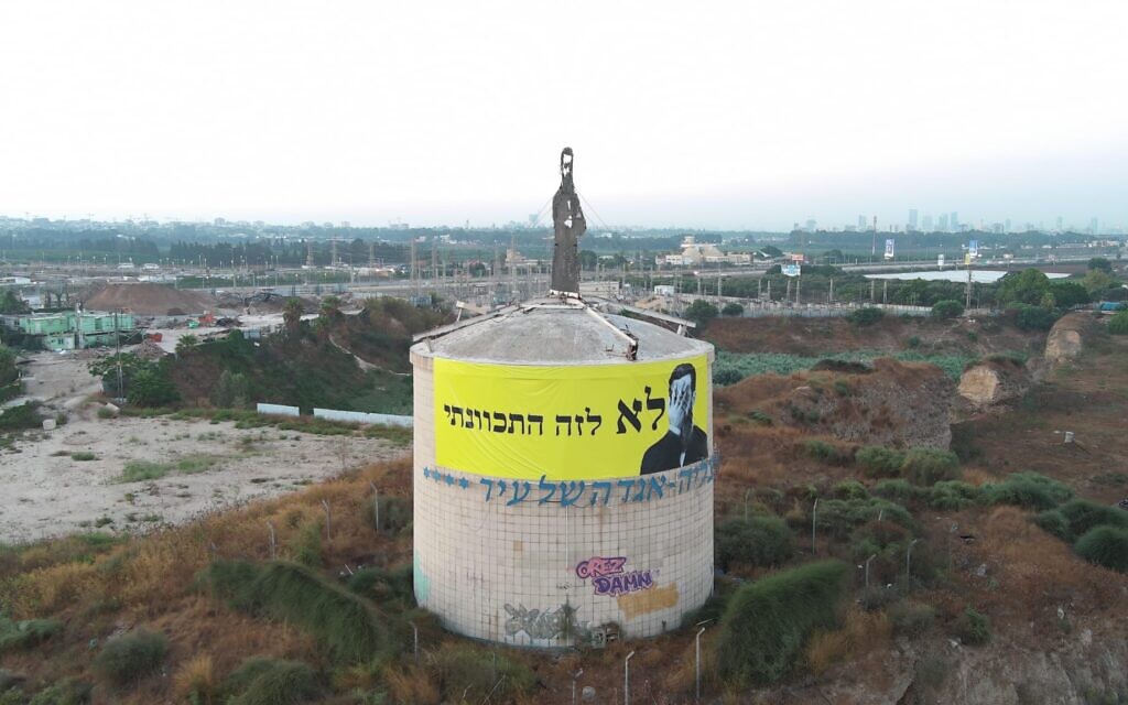 Le groupe de protestation Frères et sœurs en armes accrochant une banderole sous une statue de Theordor Herzl avec l'inscription "Ce n'est pas ce que je voulais dire", le 18 juillet 2023. (Crédit : Tali Melamed)