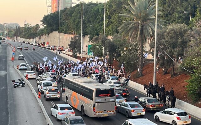 Des manifestants bloquant l'autoroute Ayalon à l'échangeur Halacha, à Tel Aviv, le 24 juillet 2023. (Crédit : Naomi Lanzkron)