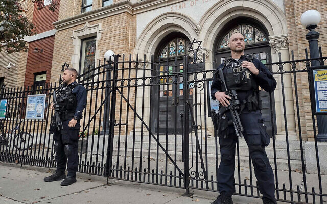 Des policiers montant la garde devant la Synagogue unie de Hoboken, à Hoboken, dans le New Jersey, le 3 novembre 2022. (Crédit : AP Photo/Ryan Kryska)