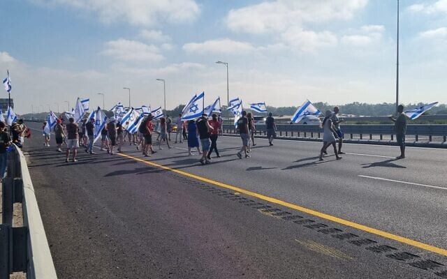 Des manifestants contre la réforme du système judiciaire bloquant la Route 2, près de Beit Yanaï, 18 juillet 2023. (Crédit : Gal Hagi)