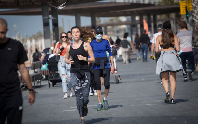 Des Israéliens font de l'exercice sur la promenade de la plage de Tel Aviv, lors d'un confinement COVID à l'échelle nationale, le 3 février 2021. (Crédit : Miriam Alster/Flash90)
