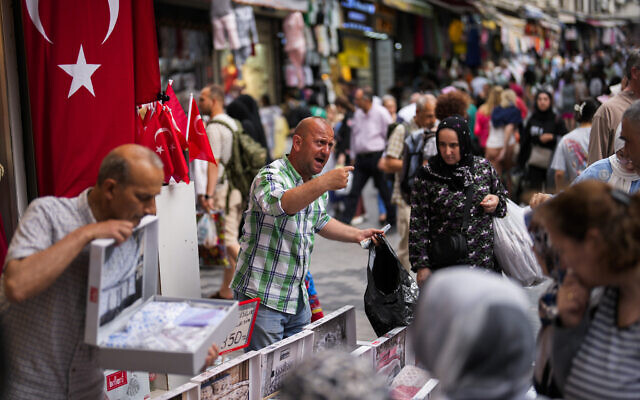 Des vendeurs s'occupent des clients dans un marché de rue dans le quartier commercial d'Eminonu à Istanbul, en Turquie, le 16 juin 2023. Illustration (Crédit : Francisco Seco/AP)