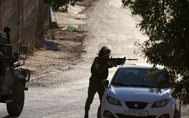 Un agent de la Police des frontières vise une arme lors d'affrontements avec des Palestiniens dans la ville de Beita en Cisjordanie, le 21 août 2023. (Crédit : Jaafar ASHTIYEH / AFP)