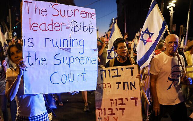 Des manifestants brandissent des drapeaux et portent des pancartes lors d'une manifestation contre le plan de refonte judiciaire du gouvernement israélien le 2 août 2023. (Crédit : Jack Guez/AFP)