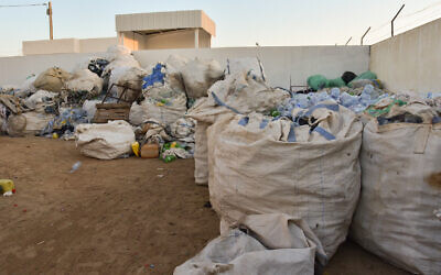 Des sacs de déchets plastiques ramassés le long de la plage par des éboueurs informels connus en Tunisie sous le nom de "barbeshas", avant d'être compactés et broyés, sur les îles Kerkennah, à quelque 20 km au large de la ville portuaire de Sfax, le 3 août 2023. (Crédit : IMED HADDAD / AFP)