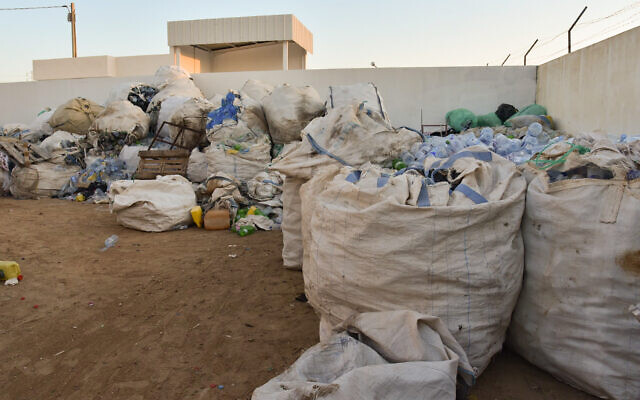 Des sacs de déchets plastiques ramassés le long de la plage par des éboueurs informels connus en Tunisie sous le nom de "barbeshas", avant d'être compactés et broyés, sur les îles Kerkennah, à quelque 20 km au large de la ville portuaire de Sfax, le 3 août 2023. (Crédit : IMED HADDAD / AFP)