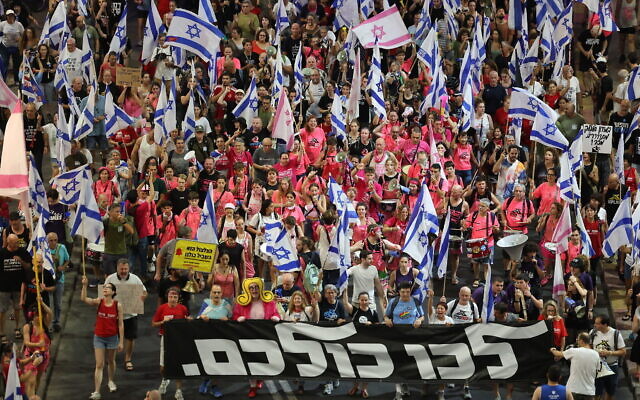Des manifestants brandissant des drapeaux et des banderoles lors d'un rassemblement contre les projets de refonte judiciaire du gouvernement, à Tel Aviv, le 12 août 2023. (Crédit : Jack Guez/AFP)