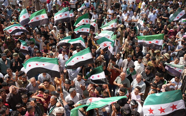 Des Syriens se rassemblent à Azaz, ville du nord du pays, tenue par les rebelles, le 25 août 2023, pour soutenir les manifestations antigouvernementales dans la ville de Sweida, dans le sud du pays. (Crédit : Rami al SAYED / AFP)