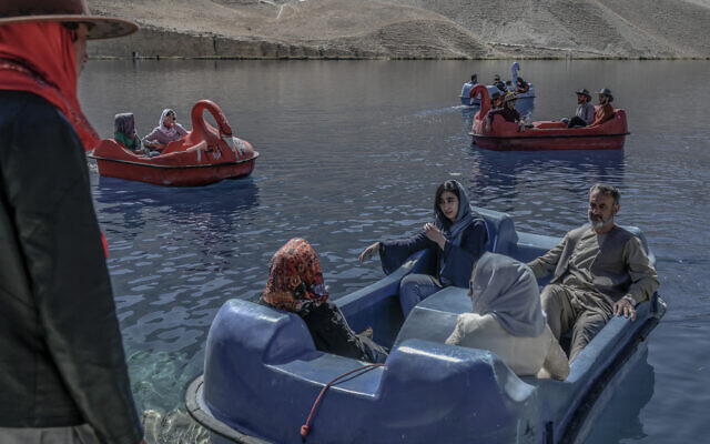 Des personnes assises sur des bateaux à aubes pour une promenade au lac Band e-Amir dans la province de Bamiyan, le 4 octobre 2021. (Crédit : Bulent Kilic/AFP/ XGTY - XGTY)